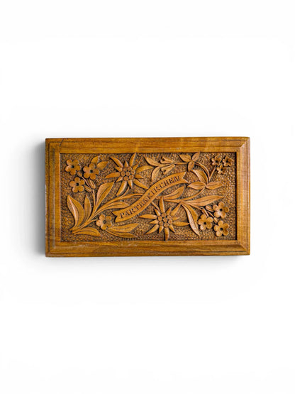 Overhead view of a rectangular hand-carved lindenwood box lid, showcasing a central "Partenkirchen" banner surrounded by intricate Alpine floral motifs and a textured stippled background.