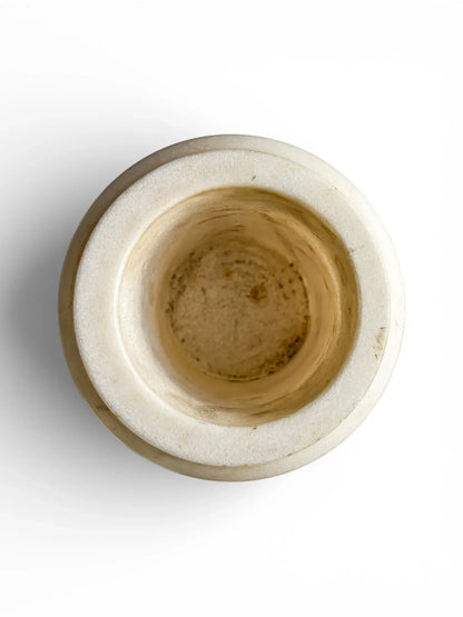 Interior view of a solid alabaster urn showing the thick-walled construction and natural stone texture of the vessel.