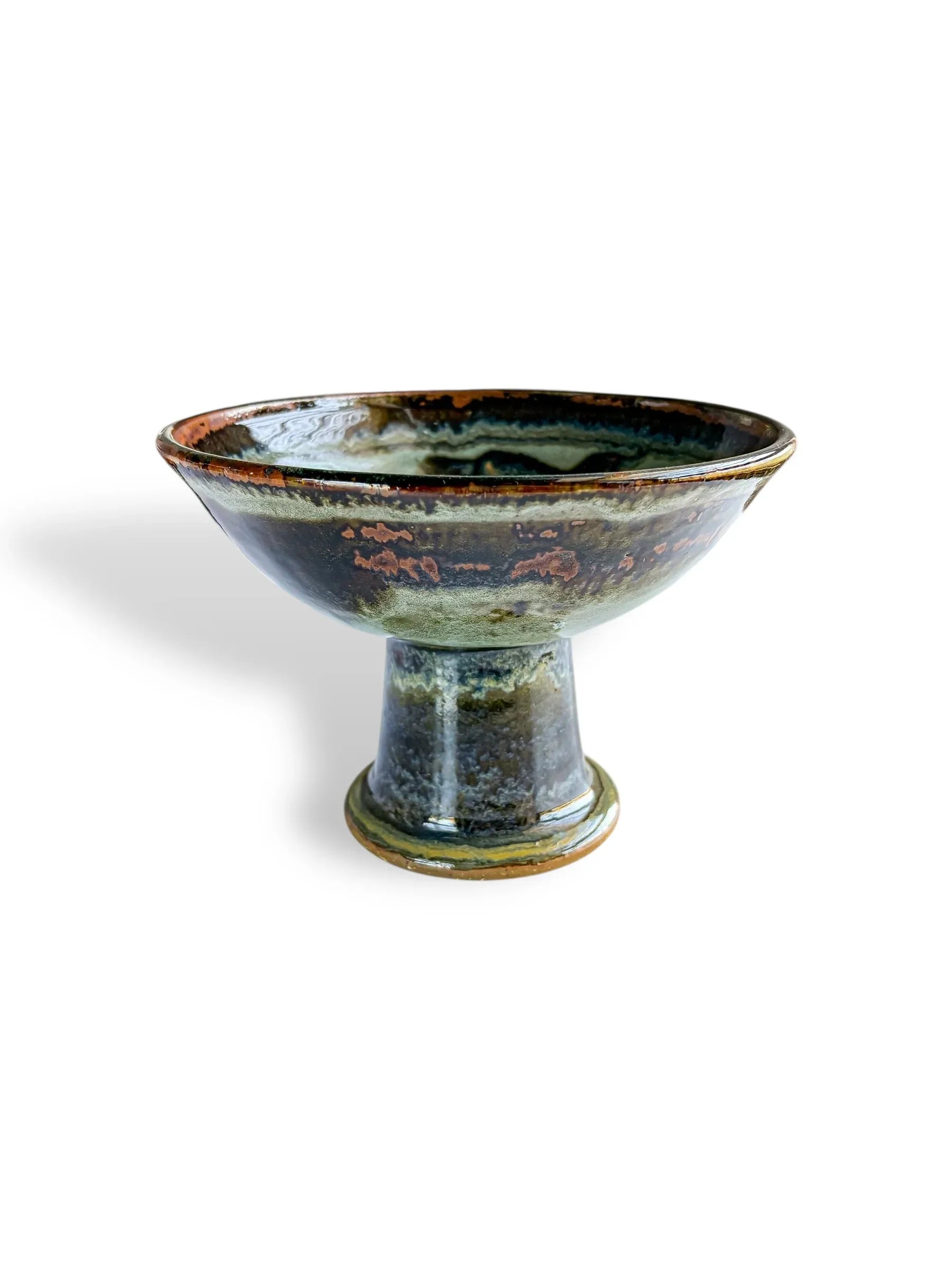 Handcrafted ceramic pedestal bowl with glossy green and brown glaze, rustic pottery art