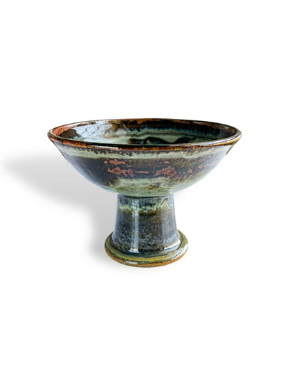 Handcrafted ceramic pedestal bowl with glossy green and brown glaze, rustic pottery art