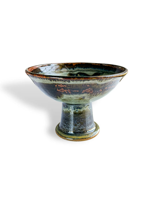 Handcrafted ceramic pedestal bowl with glossy green and brown glaze, rustic pottery art