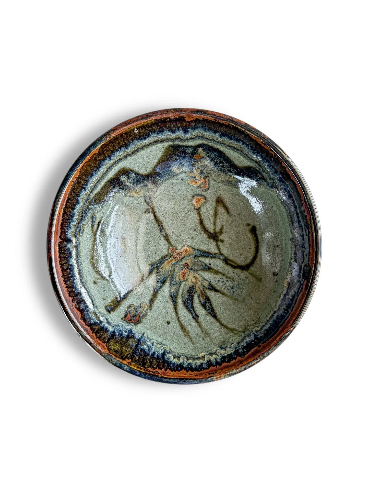 Handcrafted ceramic bowl with green glaze and abstract brown and blue floral design