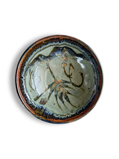 Handcrafted ceramic bowl with green glaze and abstract brown and blue floral design