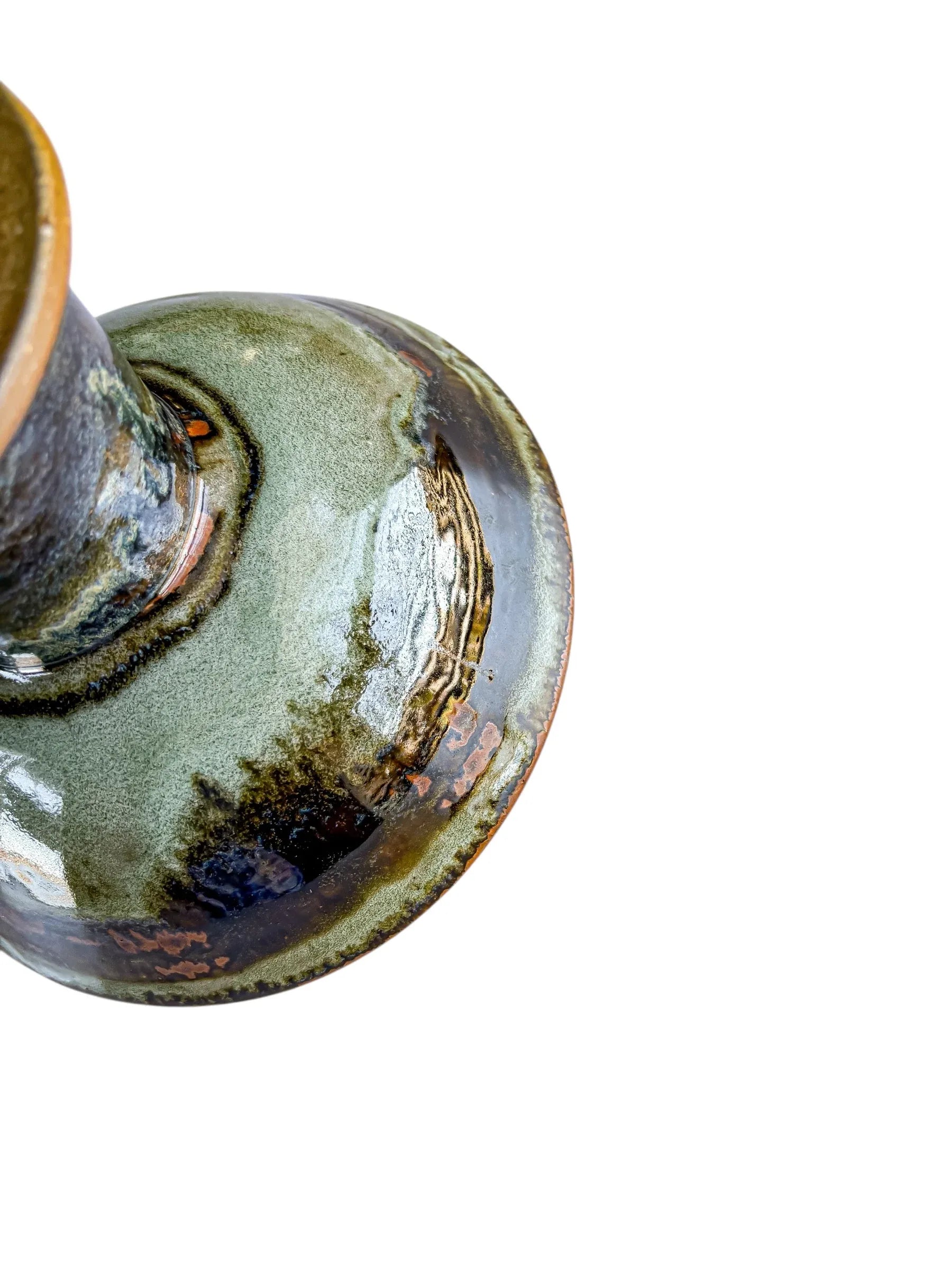 Glossy ceramic vase with green and brown glaze on white background