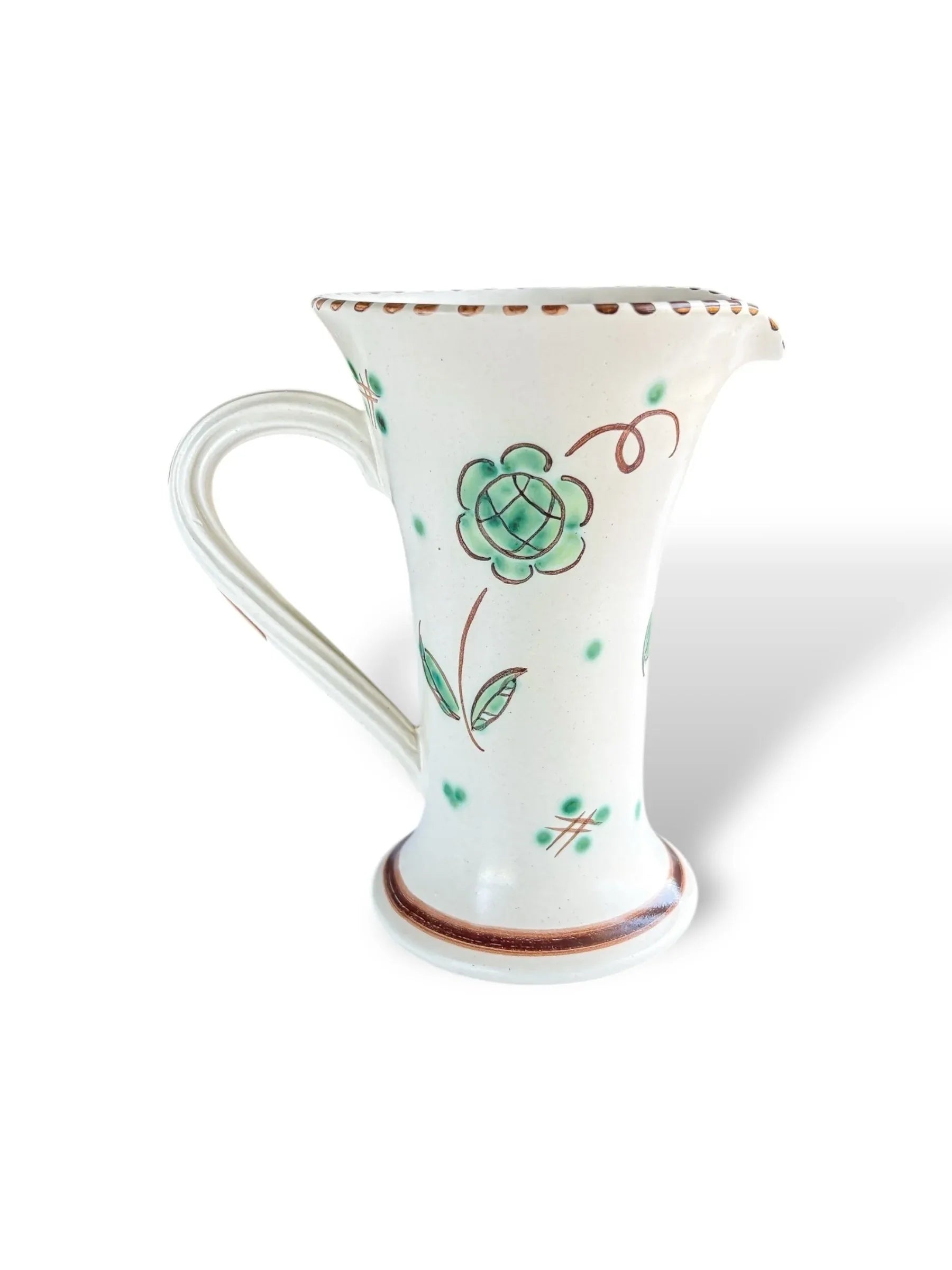 White ceramic pitcher with green floral pattern and brown detailing on rim and base