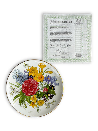 Decorative porcelain plate with colorful floral design and gold rim, accompanied by German authenticity certificate