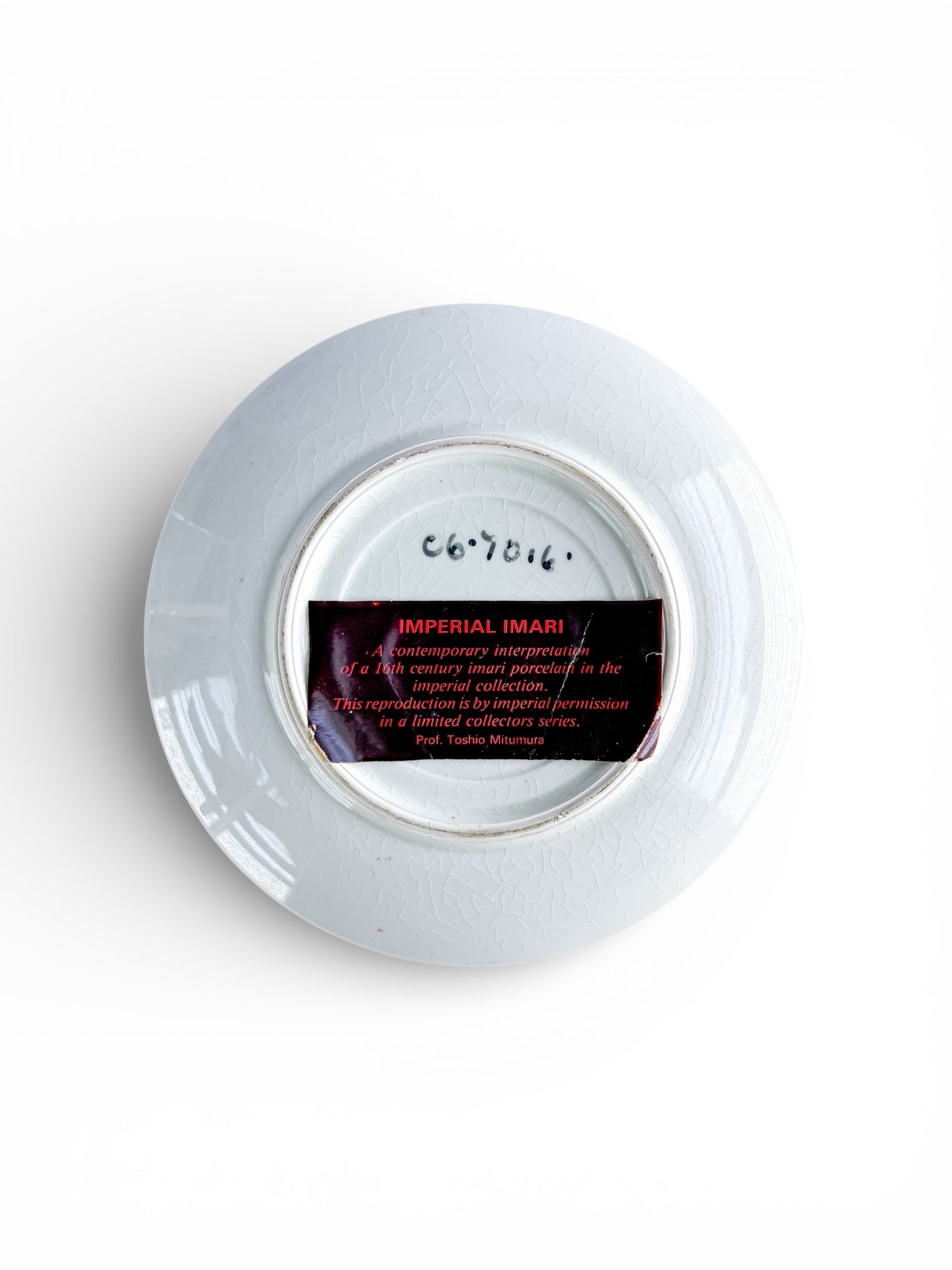 Back of a white Imperial Imari porcelain plate with label detailing 16th century reproduction in limited collectors series