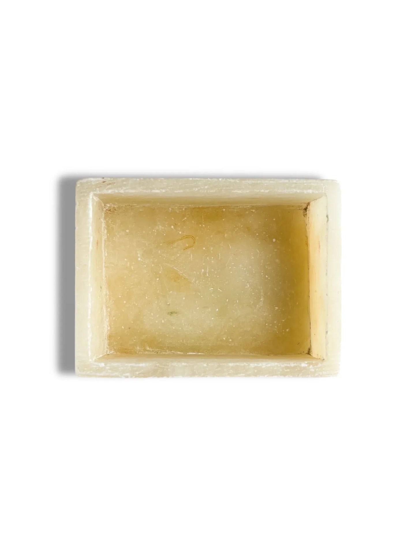 Top view of rectangular translucent beige stone soap dish with shadow on white background