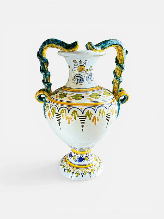 Vintage Italian Majolica amphora with hand-painted Raffaellesco motif and iridescent lustre serpent handles on a crisp white background.