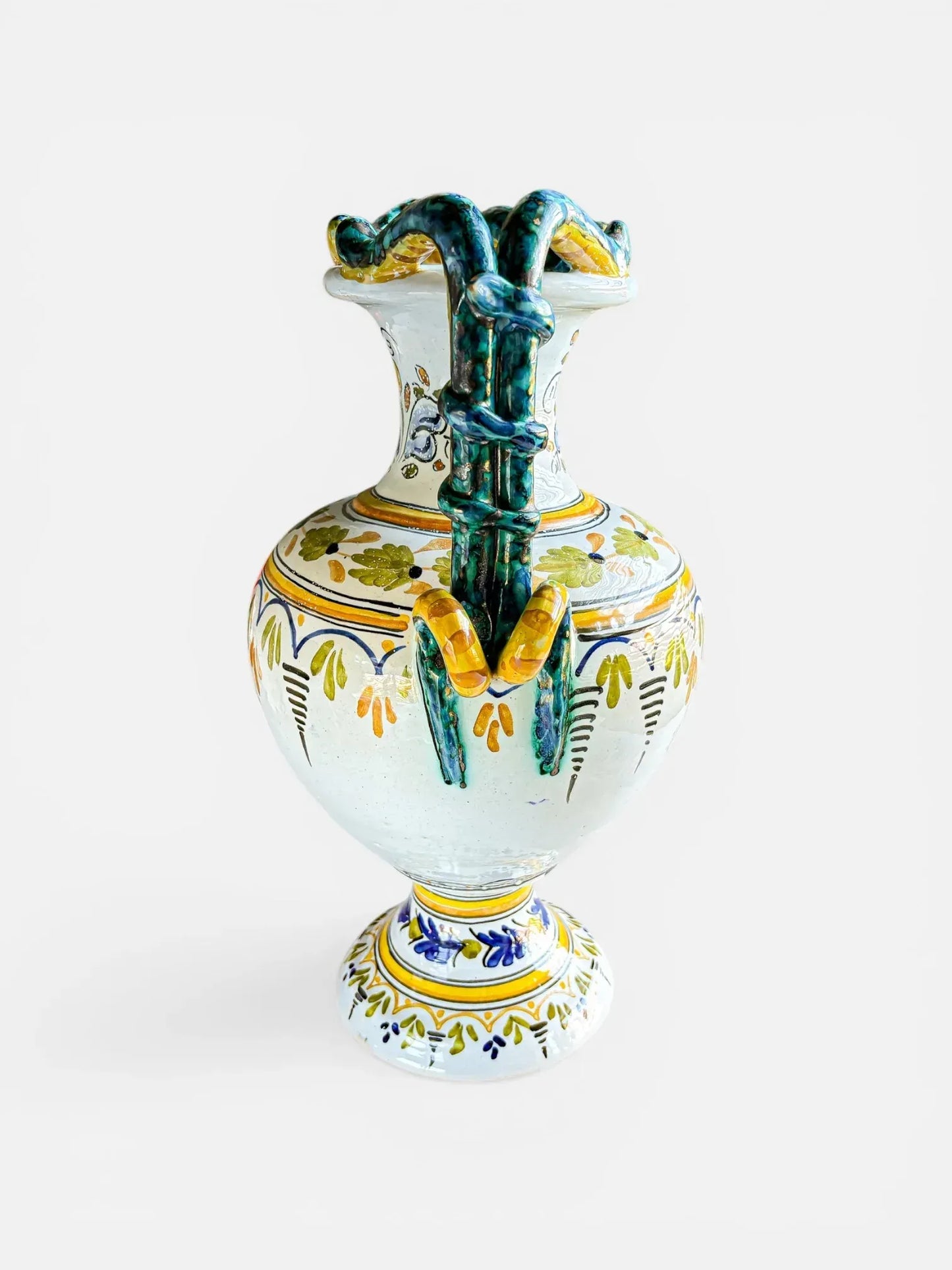 Detailed side view of a Deruta pottery amphora showing the coiled green serpent handles and traditional Italian Renaissance floral patterns.