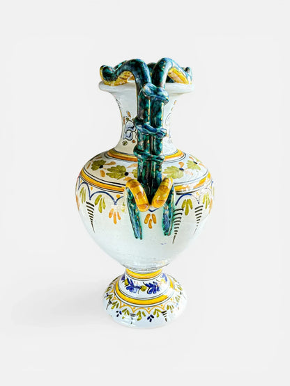 Detailed side view of a Deruta pottery amphora showing the coiled green serpent handles and traditional Italian Renaissance floral patterns.