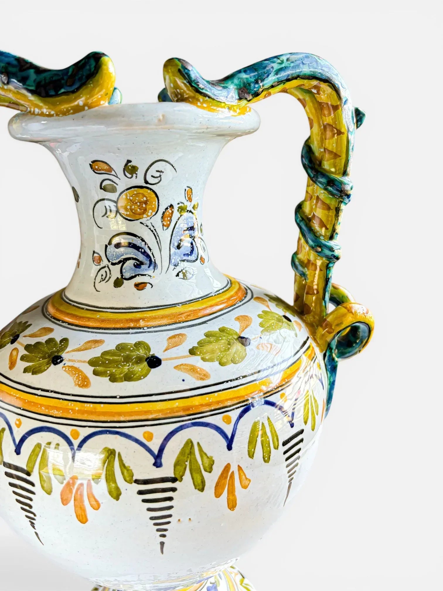 Hand-painted Italian ceramic vase featuring twin serpent handles and cobalt blue and ochre yellow decorative details.