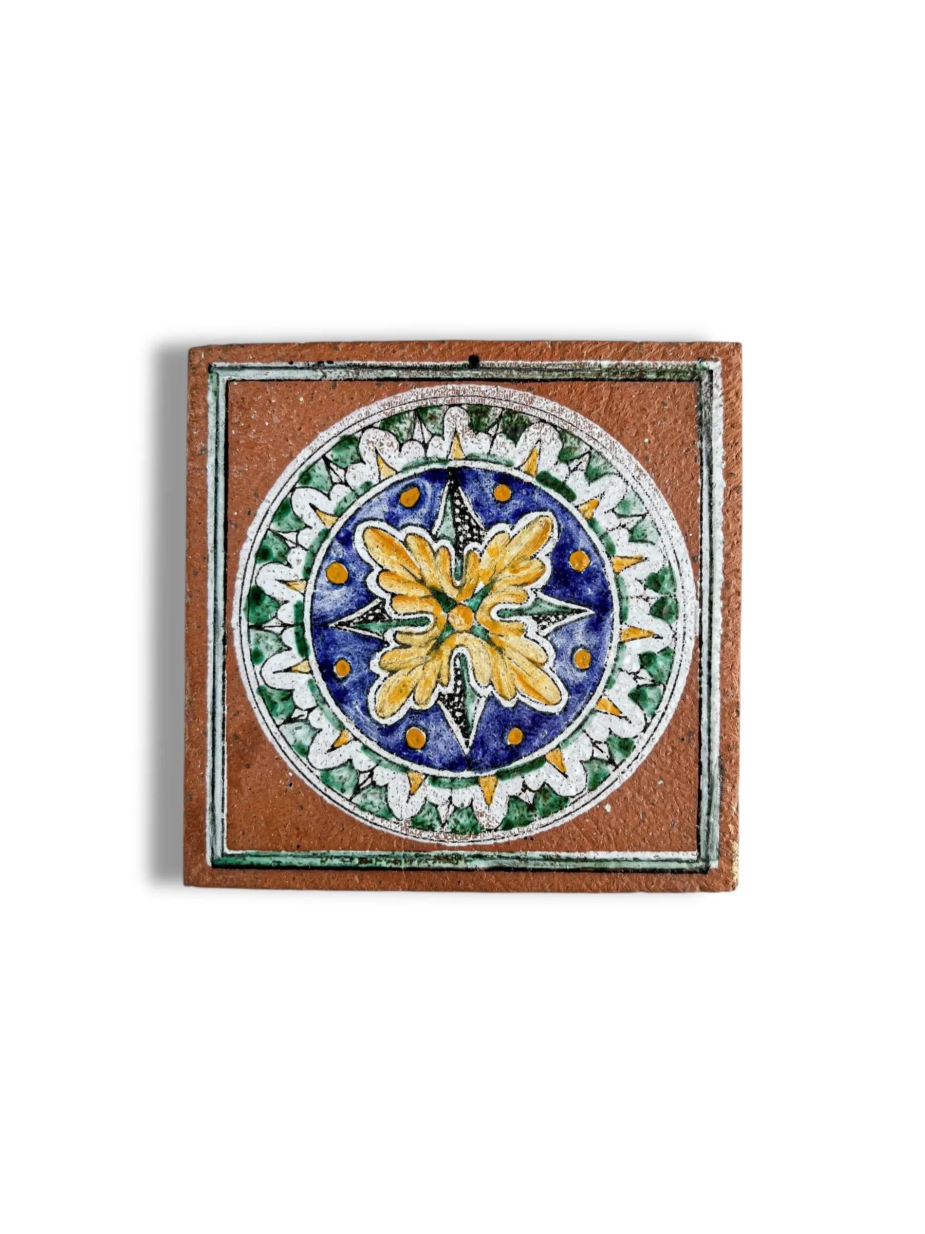 Decorative ceramic tile with colorful circular floral and geometric pattern on terracotta background