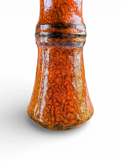 Close-up of orange fat lava glaze with volcanic texture and dark brown banding on Jasba Keramik vase