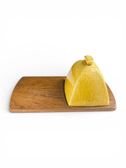 Yellow ceramic butter dish with lid on wooden tray, vintage tableware on white background