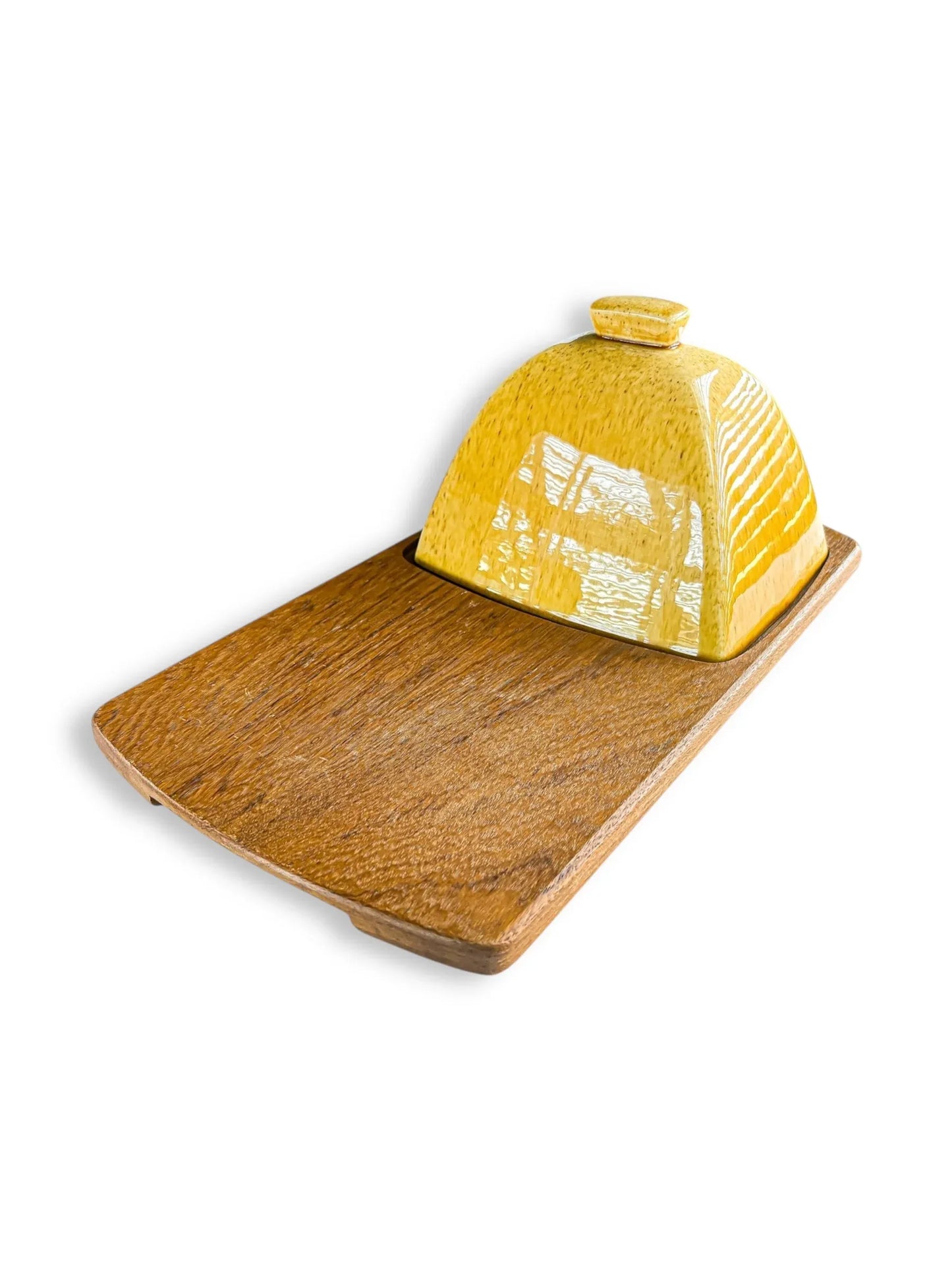 Wooden serving board with a glossy yellow ceramic butter dish cover