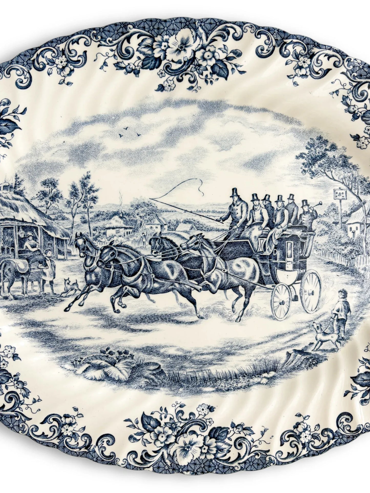 Vintage porcelain platter with blue floral border and horse-drawn carriage scene, collectible tableware
