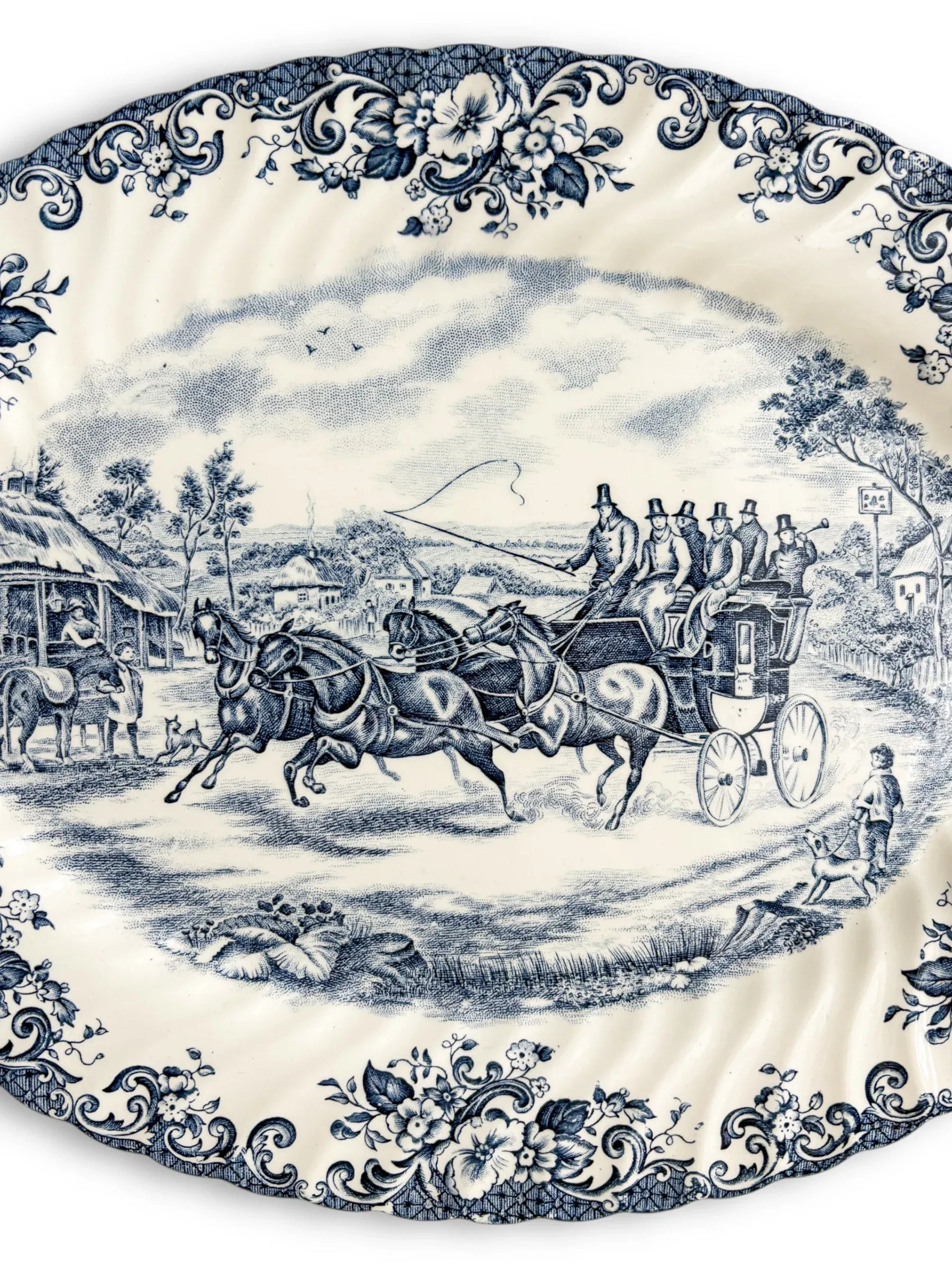Vintage porcelain platter with blue floral border and horse-drawn carriage scene, collectible tableware