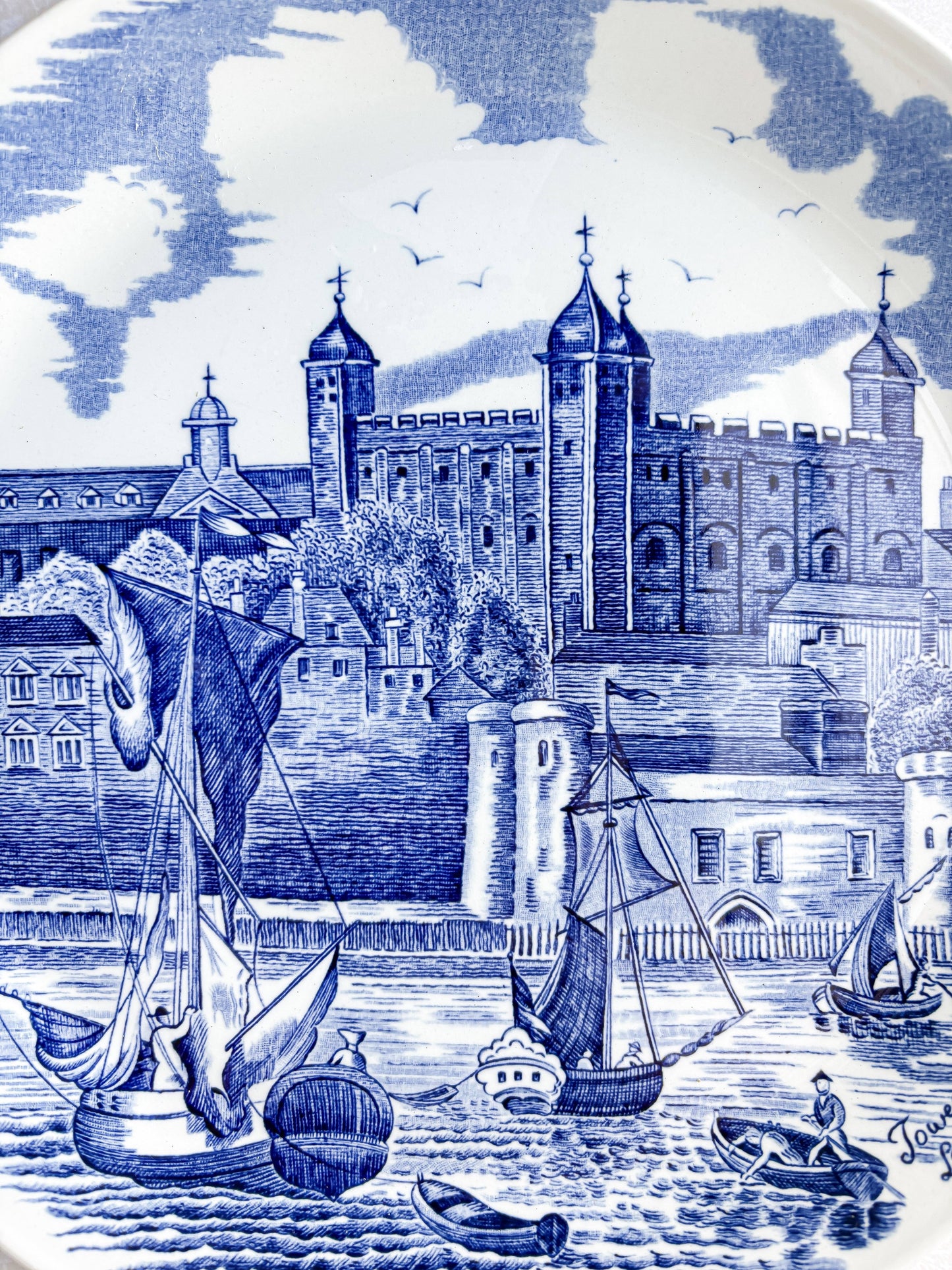 Detailed close-up of the hand-engraved blue transferware on a Johnson Bros plate, showing the intricate stonework of the Tower of London.