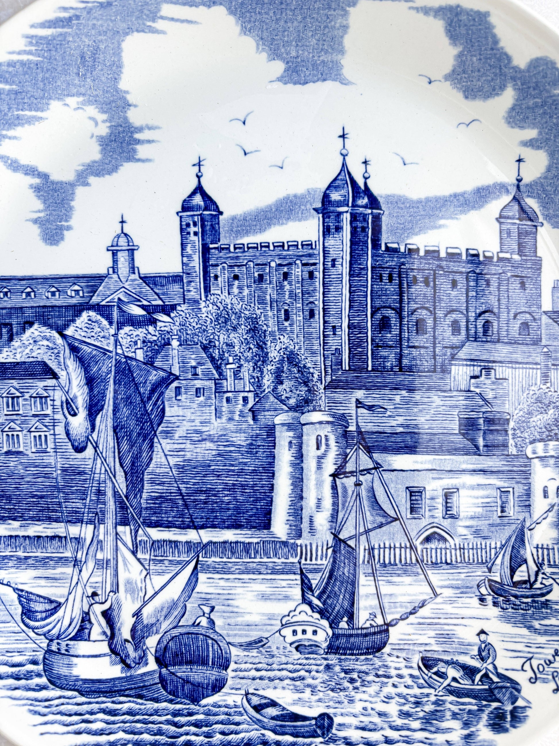 Detailed close-up of the hand-engraved blue transferware on a Johnson Bros plate, showing the intricate stonework of the Tower of London.