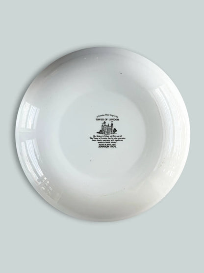 The backstamp of a Johnson Bros England ironstone plate with a historical inscription about the Tower of London and "Genuine Hand Engraving" mark.
