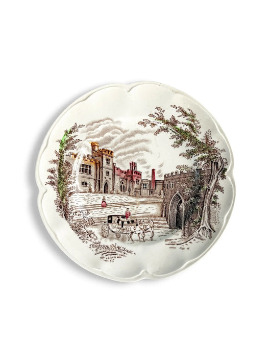 Vintage decorative plate with castle scene, horse-drawn carriage, and scalloped edges