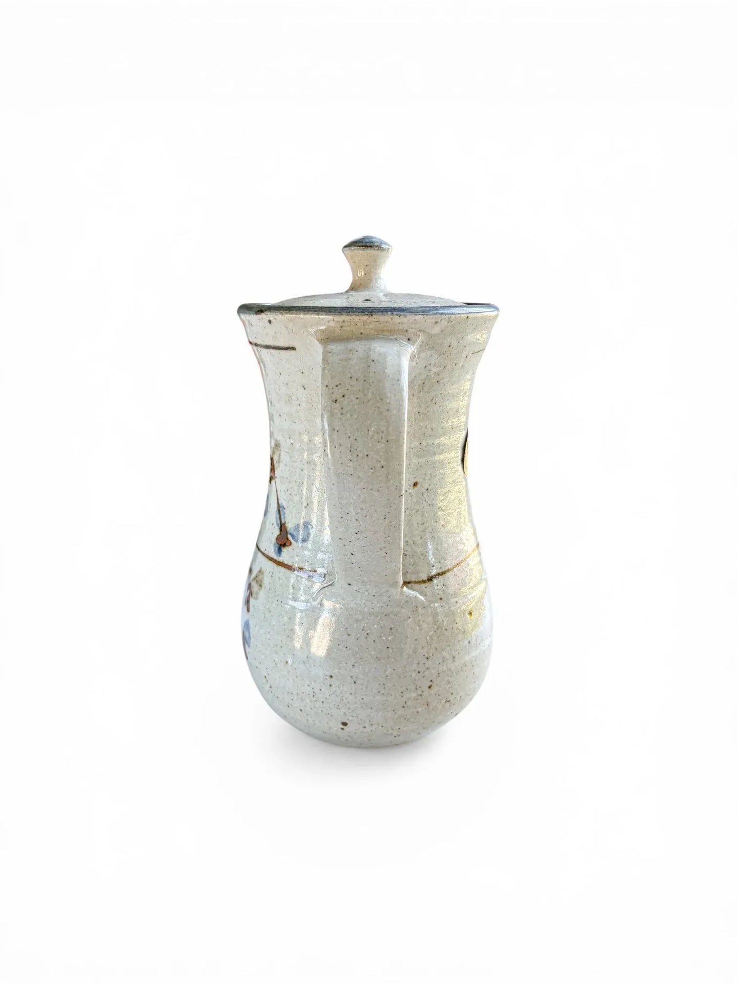 A rear-facing view focusing on the sturdy, hand-pulled stoneware handle of the Kolonyama server. The shot highlights the seamless attachment to the tapered body and the clean, minimalist lines of the mid-century design.