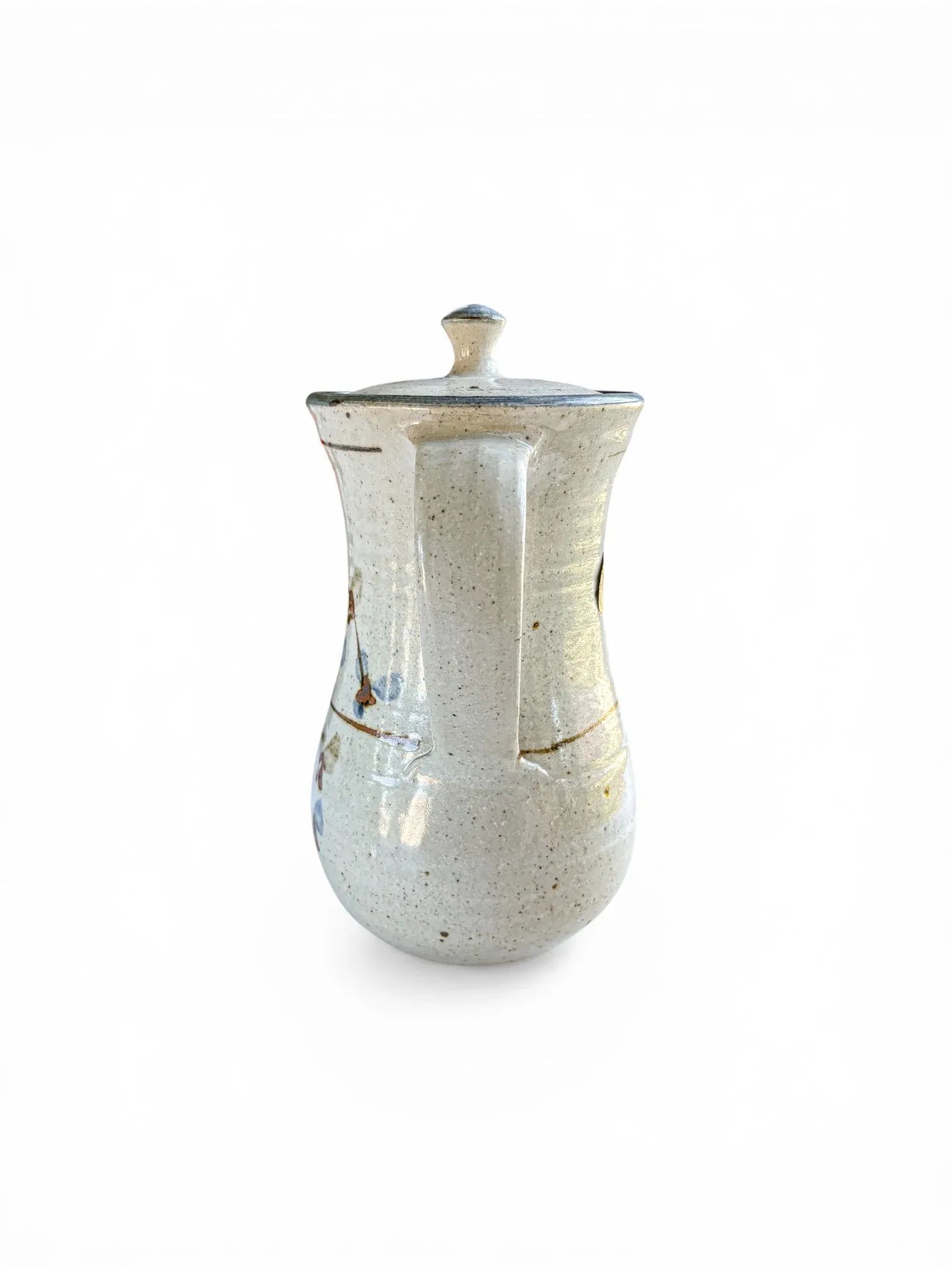 A rear-facing view focusing on the sturdy, hand-pulled stoneware handle of the Kolonyama server. The shot highlights the seamless attachment to the tapered body and the clean, minimalist lines of the mid-century design.