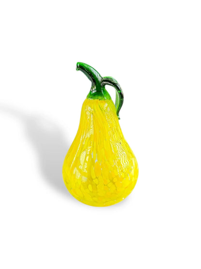 Yellow and green glass pitcher shaped like a pear with textured surface on white background