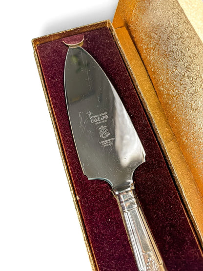 Close-up of the serrated stainless blade showing the Larko Stainless and Lewis Rose & Co Ltd Sheffield England marks, resting in the burgundy velvet lining of the gold box.