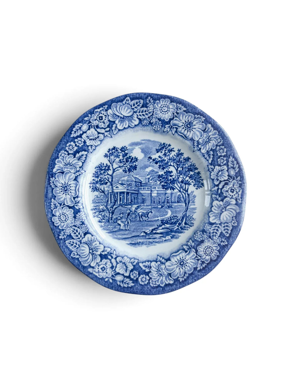 Liberty Blue Staffordshire ironstone bread and butter plate, 15.1 cm, showing the Monticello scene in cobalt transferware with a floral rose border, photographed from above on a white background.