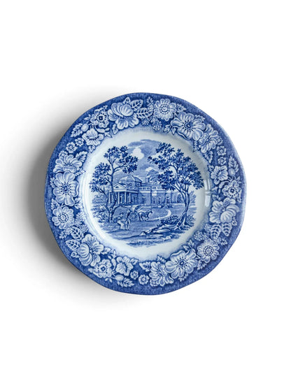 Liberty Blue Staffordshire ironstone bread and butter plate, 15.1 cm, showing the Monticello scene in cobalt transferware with a floral rose border, photographed from above on a white background.
