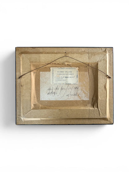 The complete reverse side of the framed vintage painting isolated on a white background. It shows aged brown backing paper, a taut wire hanging mechanism, an original "Hobby Frame" workshop label, and historical handwritten cursive notes in ink.