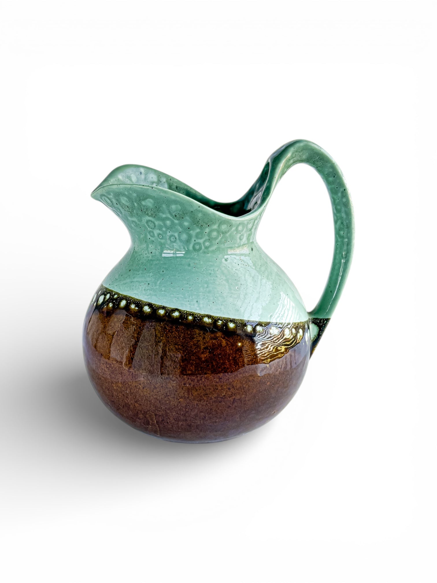 Handcrafted ceramic pitcher with teal and brown glaze and textured dot design, vintage serveware