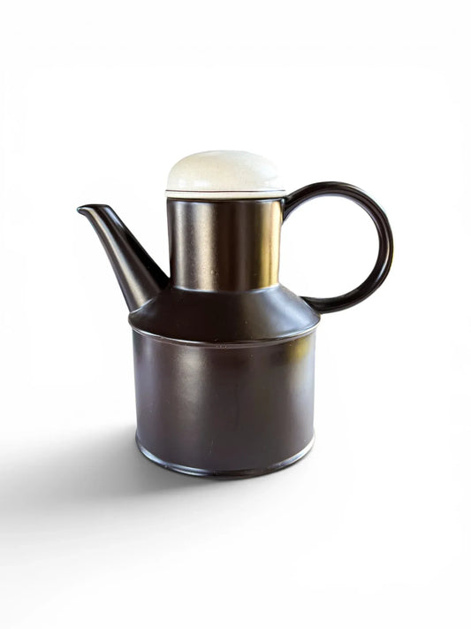 Side profile of a vintage Midwinter Stonehenge coffee pot in Onyx. The tall, cylindrical ceramic body is a deep chocolate brown with a matte finish, topped with a speckled oatmeal-colored lid against a clean white background.