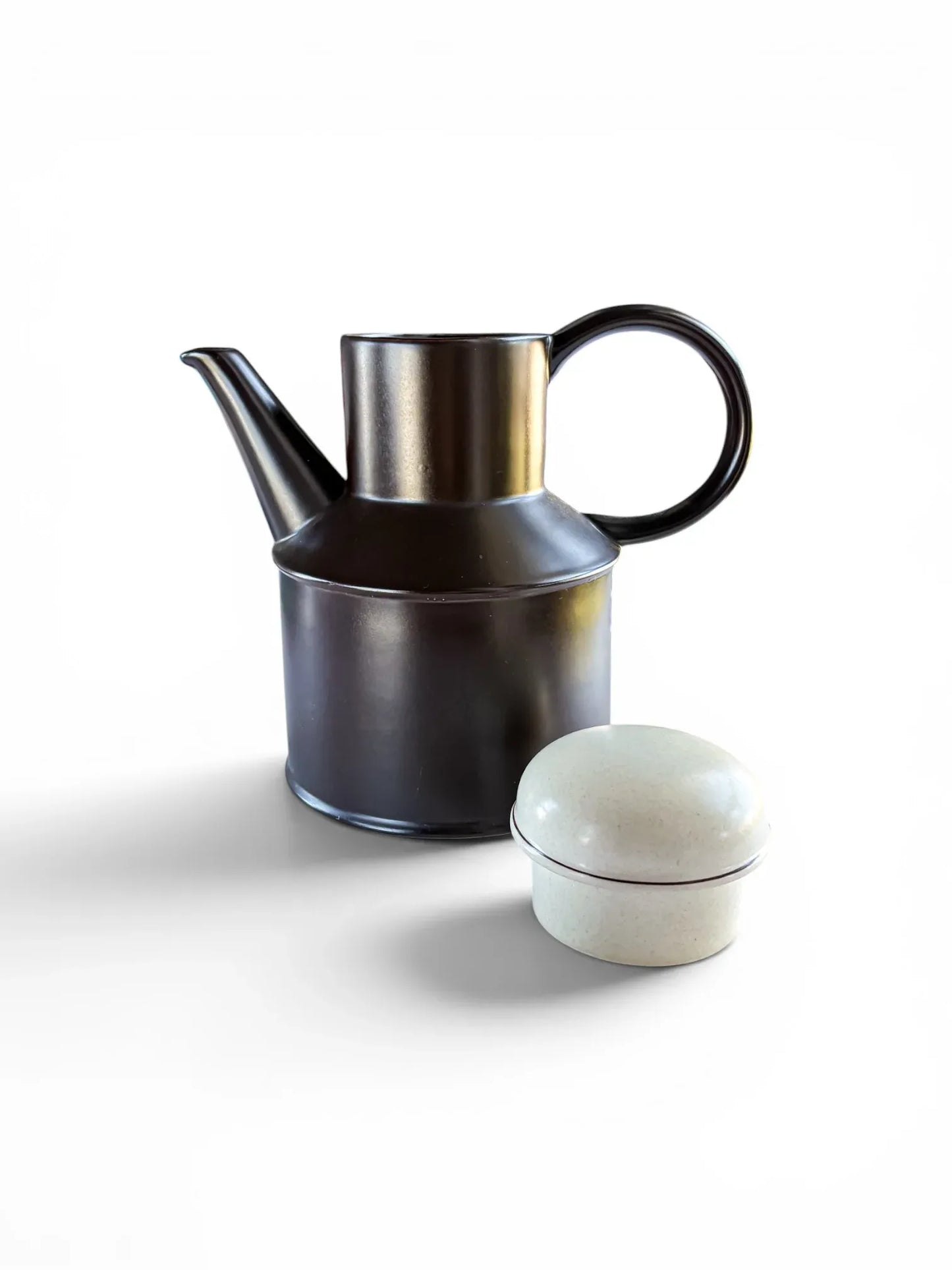 A 1970s Midwinter Stonehenge coffee pot shown with its lid placed beside it. The rich, dark earth-brown stoneware body features a bold circular handle and a high-set spout, highlighting the contrasting speckled "Creation" glaze on the lid.