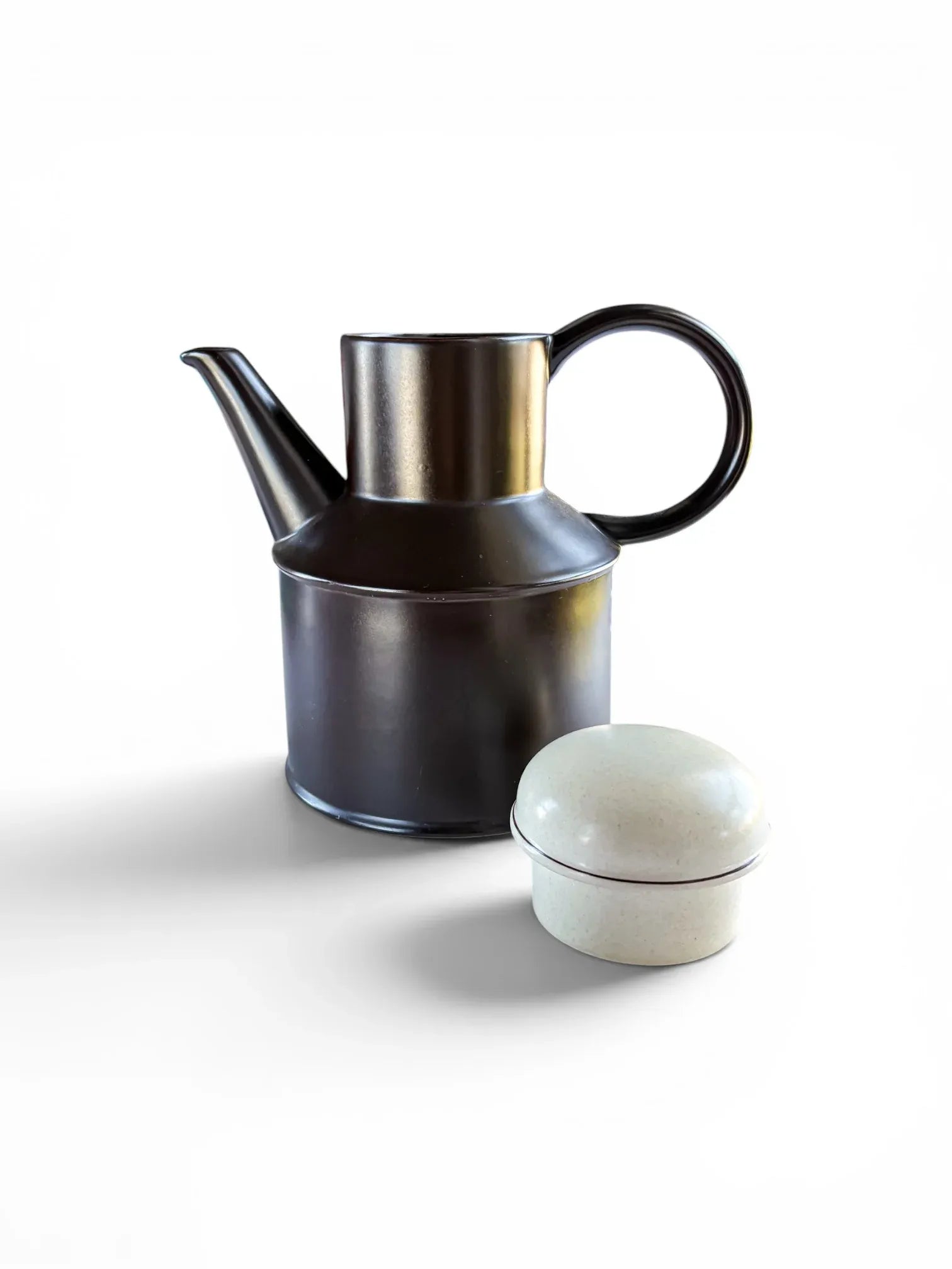 A 1970s Midwinter Stonehenge coffee pot shown with its lid placed beside it. The rich, dark earth-brown stoneware body features a bold circular handle and a high-set spout, highlighting the contrasting speckled "Creation" glaze on the lid.