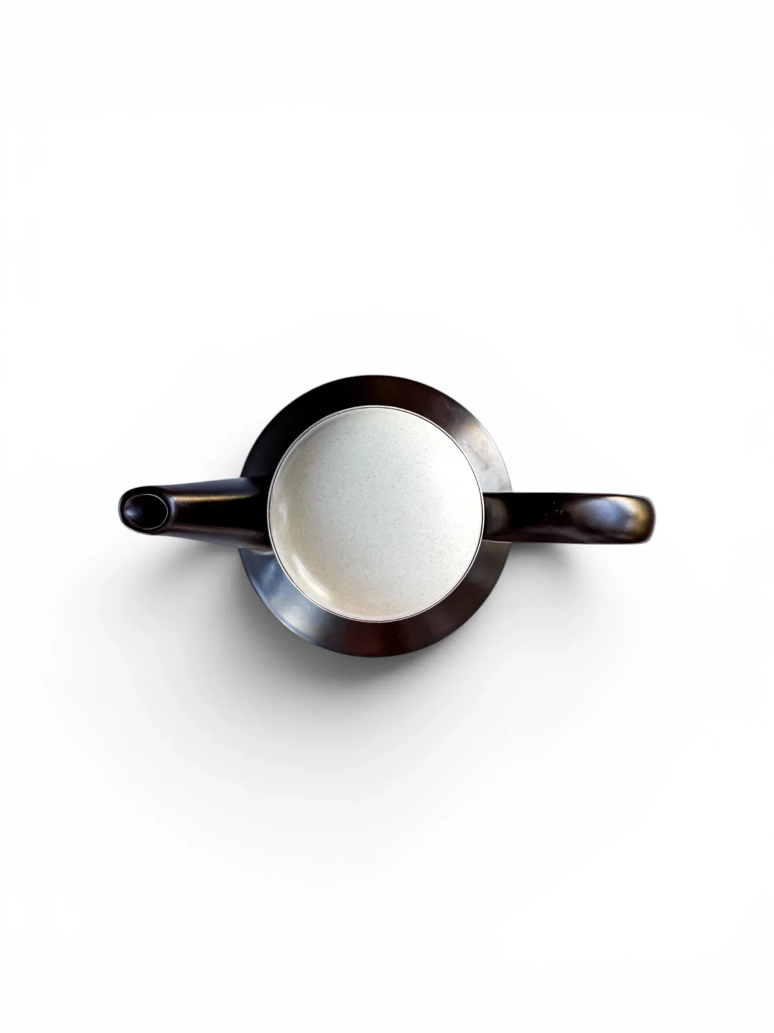 Top-down view of a Midwinter Stonehenge coffee pot. The symmetrical composition shows the dark brown spout and handle extending from the cylindrical body, with the speckled light-coloured lid centred at the top.