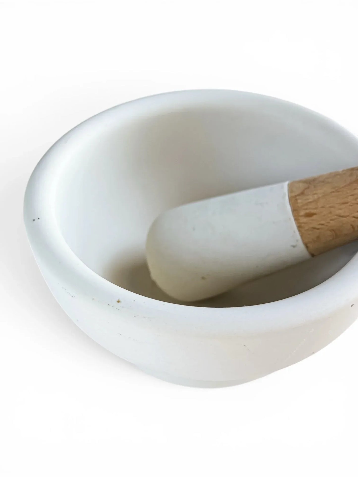 Close-up detail of the unglazed interior grinding surface of a Milton Brook porcelain mortar and the textured head of its pestle, showing its clean, excellent condition.