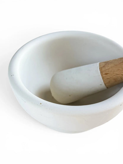 Close-up detail of the unglazed interior grinding surface of a Milton Brook porcelain mortar and the textured head of its pestle, showing its clean, excellent condition.