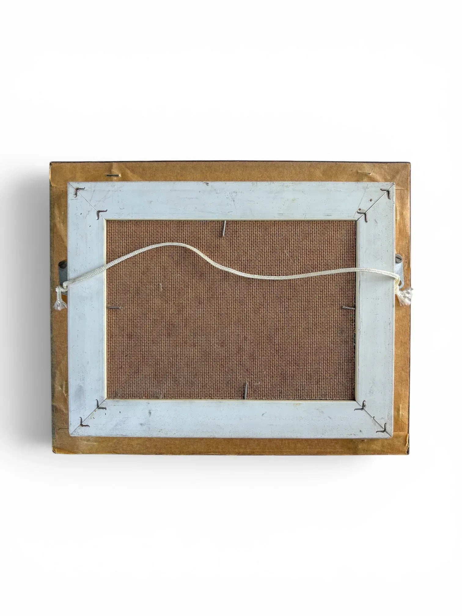 The reverse side of the framed H. Mommen oil painting against a solid white background. The back features a brown canvas board backing secured into a sturdy painted white wooden inner frame, complete with a neatly tied white hanging cord attached across the centre.