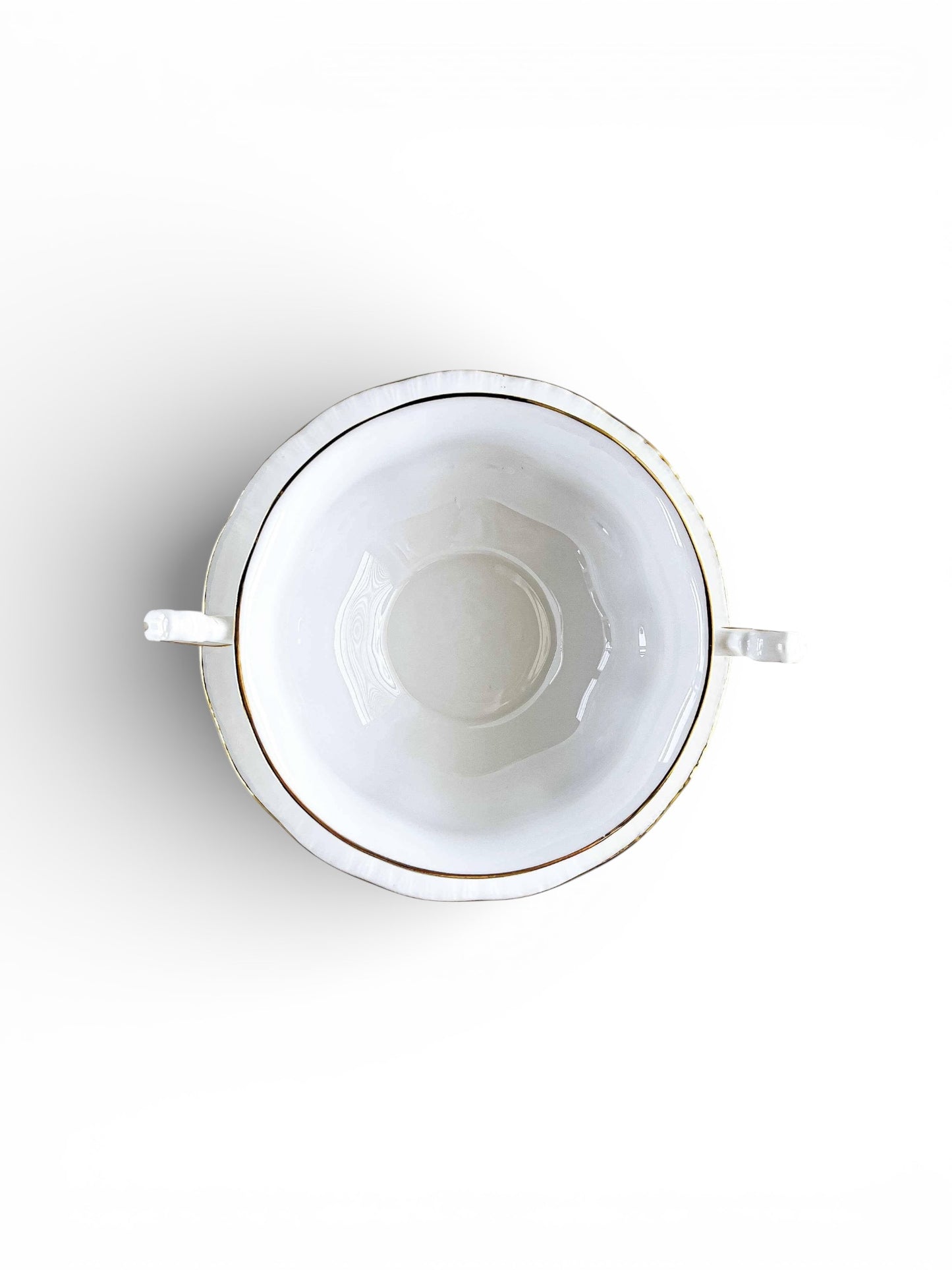 Top view of white porcelain sugar bowl with gold rim and two handles on white background