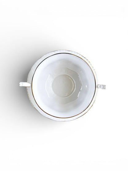 Top view of white porcelain sugar bowl with gold rim and two handles on white background