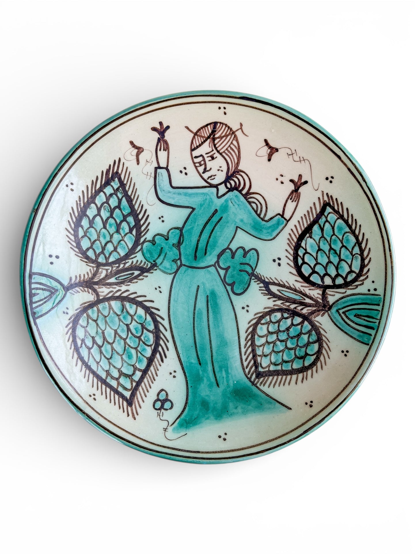 Round ceramic plate with hand-painted woman in turquoise dress surrounded by teal floral patterns