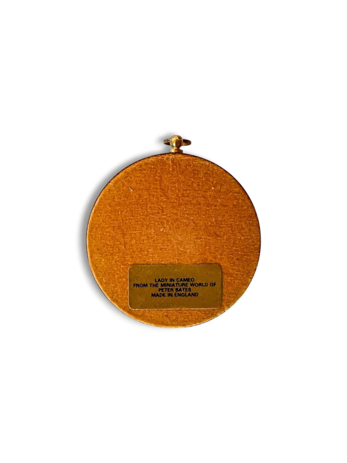 The camel velvet reverse of a Peter Bates lady cameo, with the original foil label reading Lady in Cameo, from the miniature world of Peter Bates, made in England.