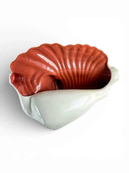 Vintage shell-shaped porcelain bowl with white exterior and glossy orange interior