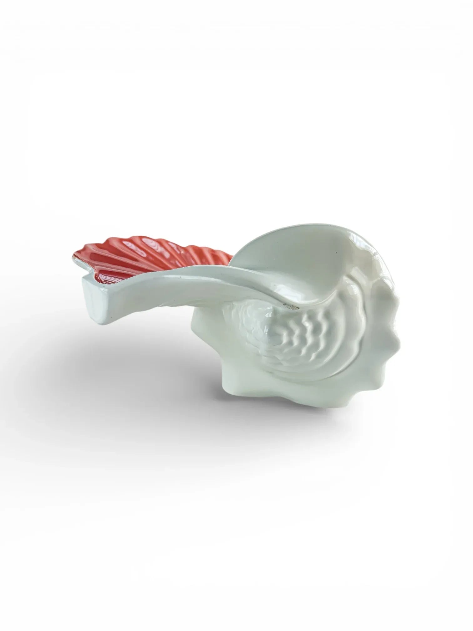 Porcelain shell-shaped serveware with white base and pink accent handle on white background