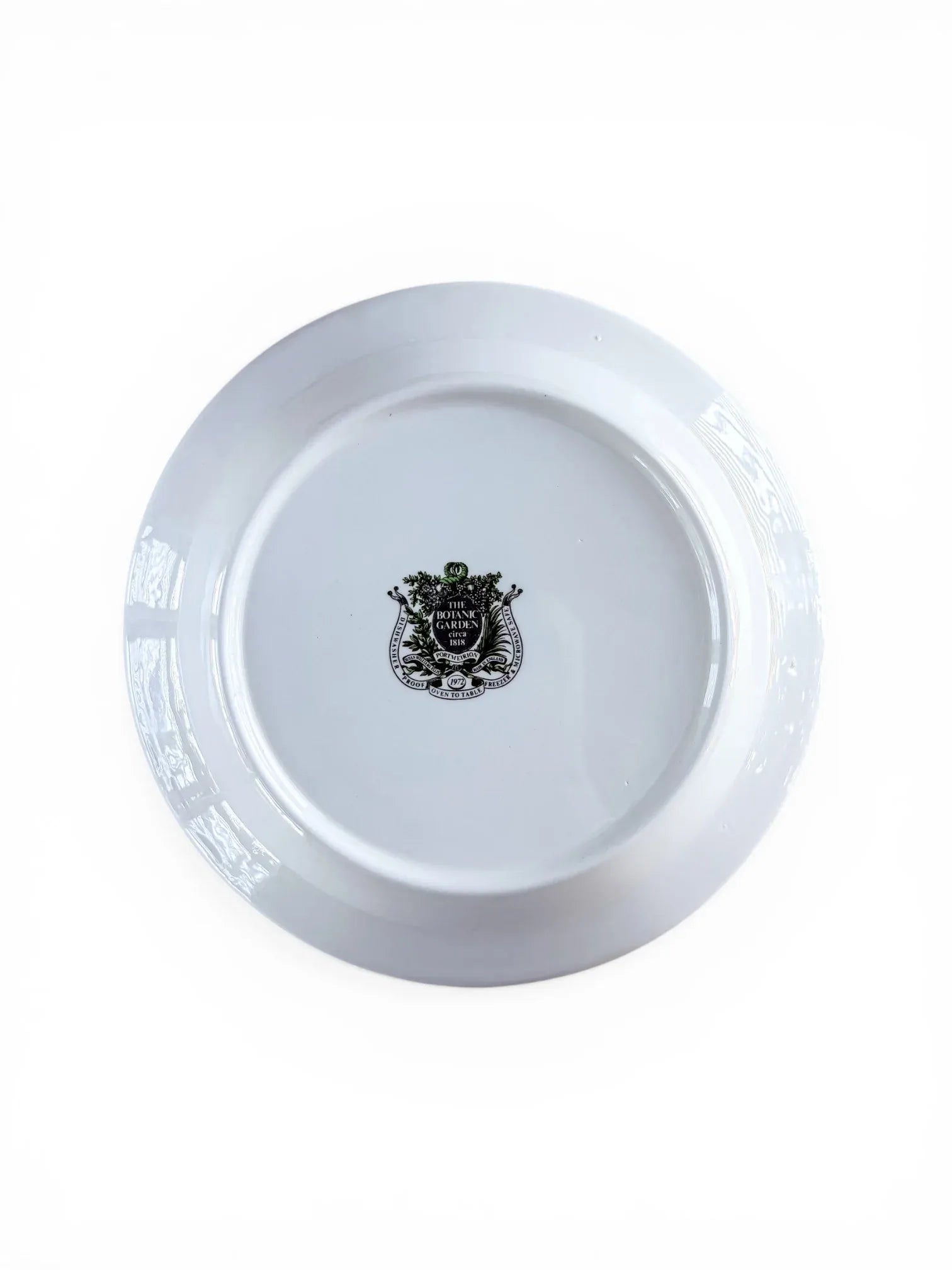 The reverse of a Portmeirion Botanic Garden plate showing the official shield-shaped backstamp, including "Dishwasher Proof," "Oven to Table," and "Made in England" branding.