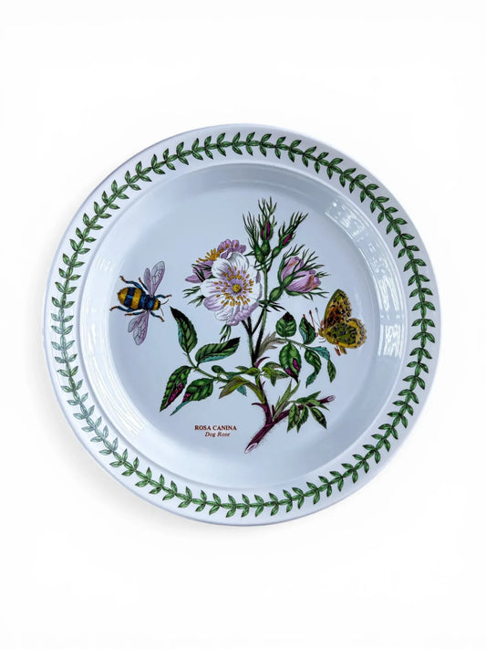 Overhead view of a Portmeirion Botanic Garden salad plate featuring the Rosa Canina (Dog Rose) motif with a bumblebee and butterfly.