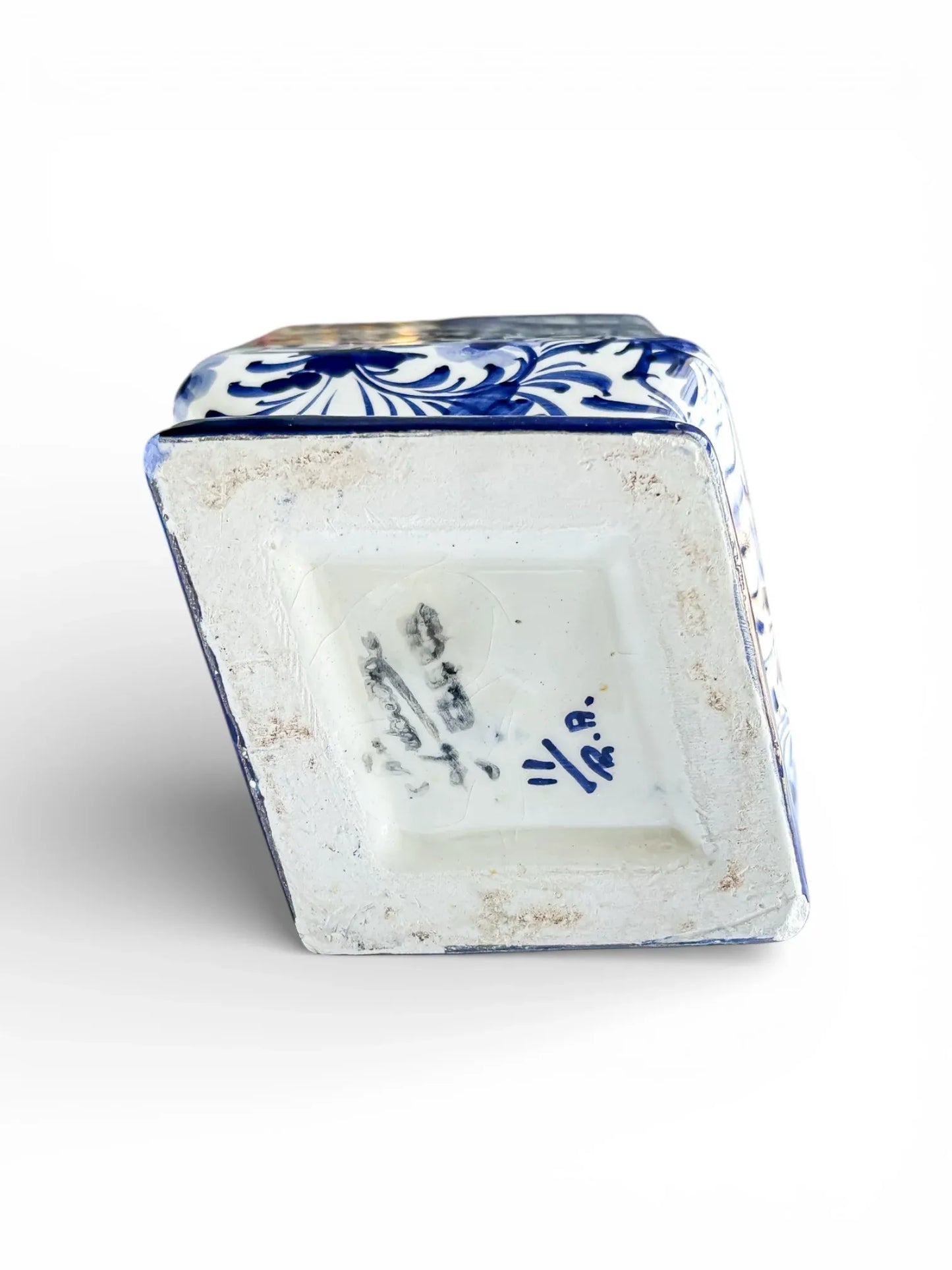 Underside of a blue and white porcelain vase with decorative floral pattern and maker's marks